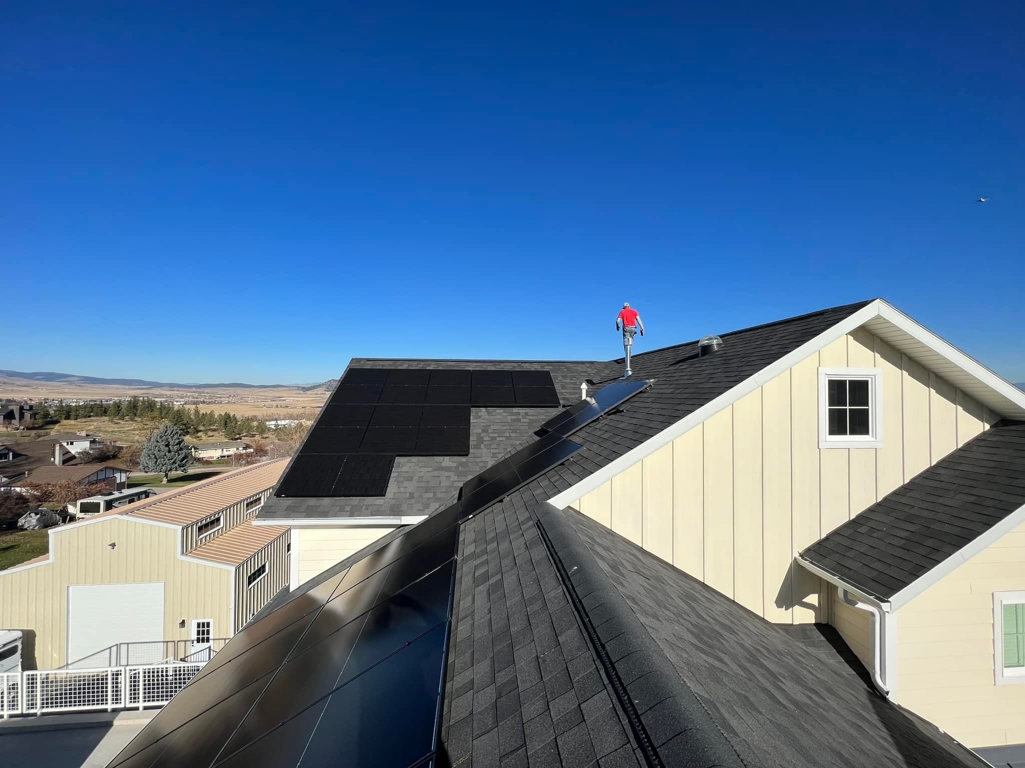 Stone and brick home with solar panels installed in green summer setting